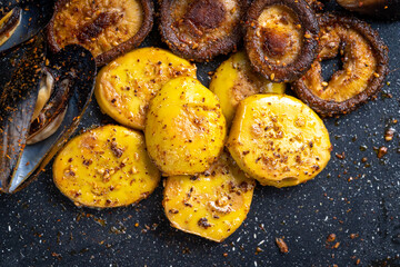 Fried eggs on iron plate on dark background