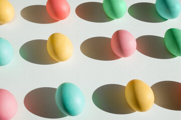 Colorful Easter eggs with deep shadows on a white background. Holiday wallpaper concept. Colorful painted eggs-a symbol of the religious holiday of Easter.