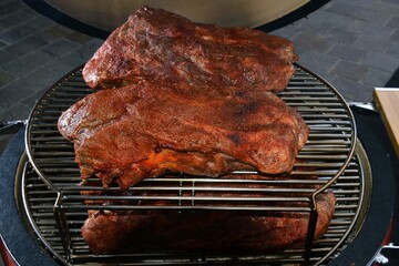 Pieces of beef cooked on the grill of an outdoor barbeque