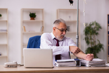 Old male employee in blood transfusion concept