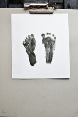 Baby foot prints on paper and archived. Foot painting with baby.
