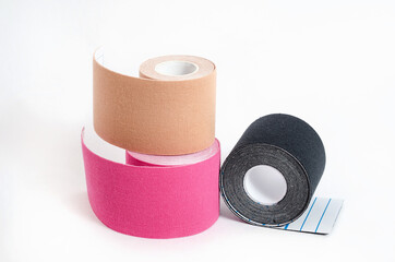 Kinesiological multi-colored tapes for fixing muscles during sports and after injuries on a white background.