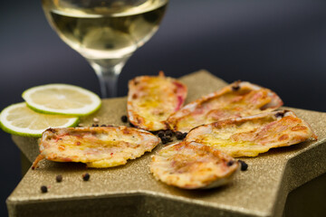 (machas a la parmesana) seashell cooked in parmesan. served on a golden star