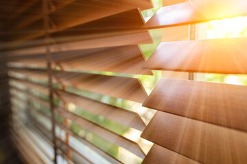Wooden blind on the window with sun rays. Office blinds. Wooden shutters blind. 