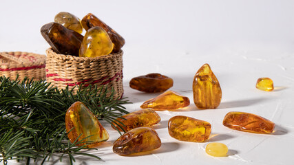Variety of magical sparkling amber stones on a white plastered surface. Material for jewelers,...