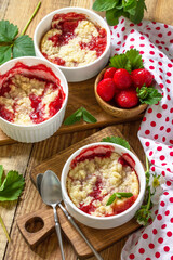 Summer dessert home cooking. Strawberries crumble in a baking dish and fresh strawberries on a...