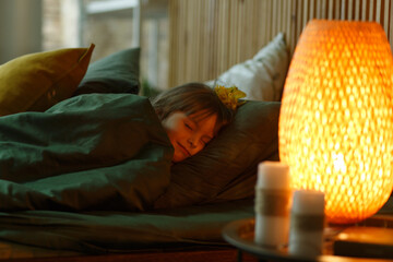 Cute little girl lying under blanket in her bed