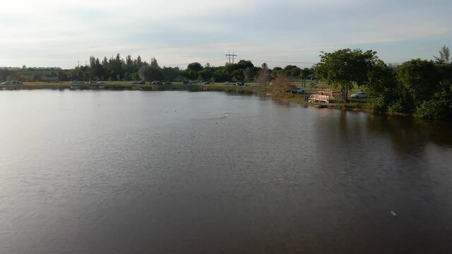 Aerial drone view towards a rc boat on a lake in Markham park, Florida