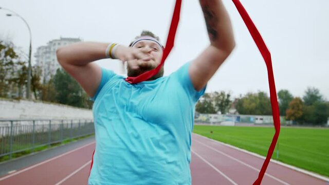 Young obese guy wants to loose the weight he running for a marathon happy and excited he arrived at the finish line in front of the camera