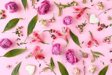 Floral pattern made of rose buds, lily flowers on pink background.