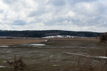 Snow melts on an agricultural field in spring
