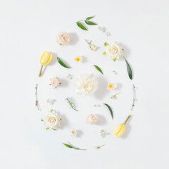 Easter egg shape arrange from colorful  spring flowers and green leafs over white background. 