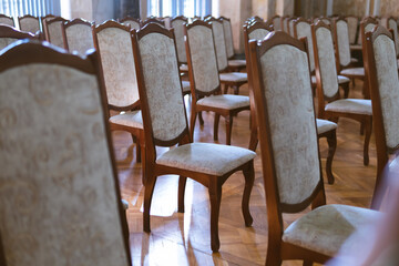 Rows of old, vintage chairs. Auditorium room. Rays of sunlight through the window. Training, meeting and business concept. selective focus