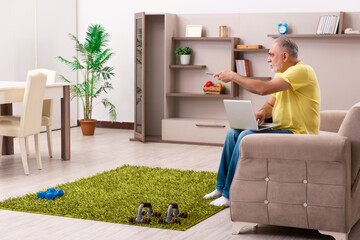 Aged man doing sport exercises at home