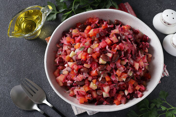 Traditional salad Vinaigrette of beets, potatoes, carrots, beans, pickles, onions and vegetable oil on dark gray background. Vegetarian food. View from above