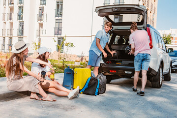 friends load car trunk with baggage