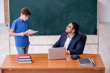 Young male teacher and schoolboy in the classroom