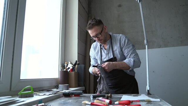 Man in apron preparing working place foe linocut workshop. Handcrafted art place to make lithograph art. 4k footage