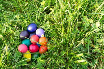Colorful eggs on green grass. Copy space.