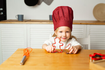 beautiful little girl in a chef's hat in the kitchen 