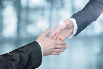 Businessmen reach out to each other to shake hands.