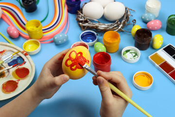 child points eggs for Easter on a blue background