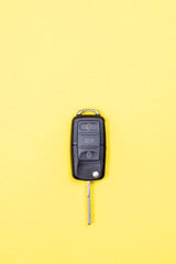 black car key over yellow background