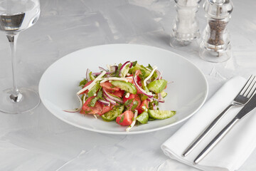 Fresh vegetable salad with oil on a light background