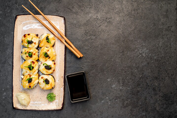 baked sushi rolls on a stone background with copy space for your text. Japanese kitchen