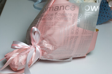 Bouquet wrapped in wrapping paper. Tied with a ribbon tied to a bow.