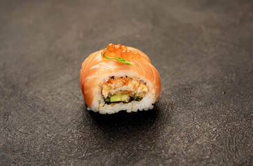 one sushi roll on a stone background