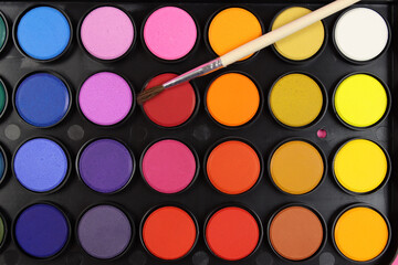 Set of watercolor paints with a brush