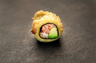 one sushi roll on a stone background	