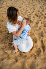 Mae amamentando filho na praia - 421335437