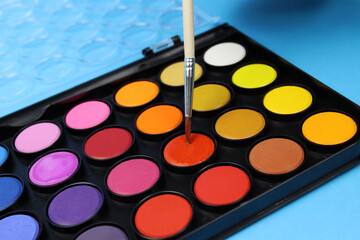 Professional set of watercolor paints with a brush close up