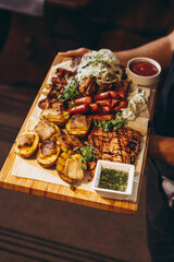 assorted various meat and vegetable dishes laid out on the village board for serving in a restaurant of Ukrainian cuisine