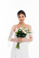 happy, pregnant bride looking at camera while holding wedding bouquet isolated on white