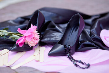 Peonies and putty knife or spatulla for beauty procedure - sugaring on a pink background with shoes. Women concept