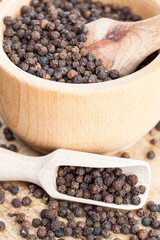 spice black pepper scattered on an old wooden table