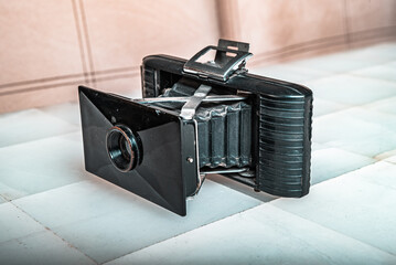 retro camera with lenses and accordion body on wooden background