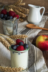 Oatmeal porridge with blueberries,raspberries  and yogurt in bowl on wooden table background.Rustic healthy breakfast..