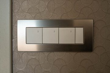 A block of four switches in a metal frame. Illumination on the switch keys.