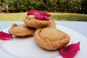 Indian traditional sweet known as Chandrakala, round deep fried sweet from india or Pakistan, eaten and cooked during festivals. Like diwali, holi, ramazan decorated with rose petals.