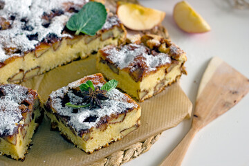 Homemade apple pie, sprinkled with powdered sugar and cut into slices. Charlotte pie with apples