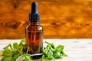 Cosmetic dark bottle with a pipette  dropper on a wooden background 