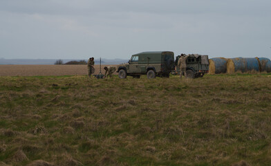 army land rover defenders and soldiers towing a trailer set about  recovering transmitter equipment, salisbury plain wiltshire 