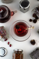 Homemade herbal tea. A remedy that boosts immunity and relieves stress. Glass teapot and tea with a healthy drink. Transparent jars with dried herbs and berries.