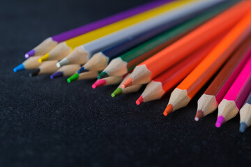 Colored pencils on a dark background. Defocus. Close-up.