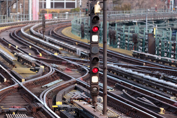 red lights on outdoor subway train tracks curving into the distance