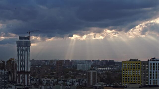Industrial city at sunset with running clouds